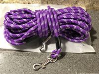 Coiled purple reflective rope leash showing length and both metal swivel snaps