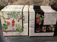 Two stacks of sealed napkin packs showing both designs