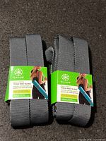 Pair of packaged gray Gaiam yoga mat slings on countertop