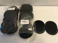 Two sealed plastic bags of black oval pocket palm combs plus two loose examples showing bristle and grip sides
