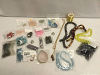 Wide shot showing all bags of beads, charms, thread spool and strands