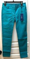 Front view of teal LPGA pants with hang tag