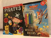 Front covers of both sticker activity books showing titles, graphics, crayon pack and sticker quantities