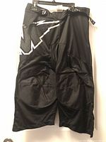 Front view of black Mission Inhaler AC-4 roller hockey pant showing graphic and overall design