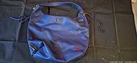 Front view of royal blue pebbled leather hobo bag showing heart stud and side zipper