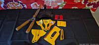 Entire lot laid out showing hedge shear, yellow scrapers/boards, sanding blocks, utility knife