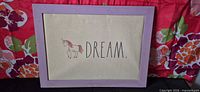 Front view showing unicorn illustration, DREAM text, lavender frame