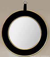 Front view of round mirror showing black velvet border and brass edge