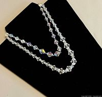 Both crystal bead necklaces displayed on black background