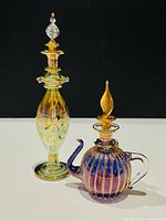 Front view of both perfume bottles showing colors, shapes and stoppers