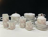 Full set overview showing stacked plates, cups, lidded pieces