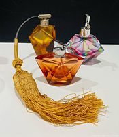 Group shot of all three faceted crystal perfume bottles showing colors and tassel