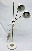 Full view of floor lamp showing base, poles, two shades, cord