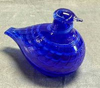 Left side view of cobalt blue art glass bird showing feather texture and beak