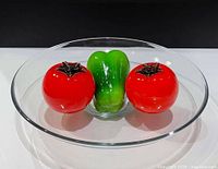 overall view of bowl with two tomato and one bell pepper paperweights