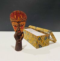 Figurine standing beside opened patterned box