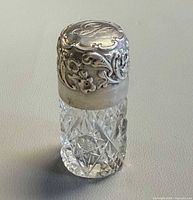 Full perfume bottle showing cut glass body and sterling cap