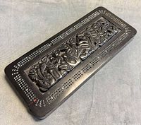 Top view of entire cribbage board showcasing Haida relief and hole pattern