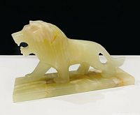 Left front view of carved alabaster-onyx lion on base