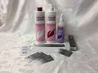 Photo of hair care products and gift certificate laid out on a white cloth background