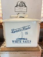 Front view of enamel laundry powder tin with lid and scoop showing graphic