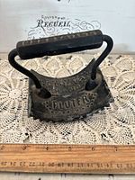 Front angled view of Geneva cast iron hand fluter showing handle and embossed lettering