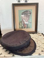 Cap and framed needlepoint together