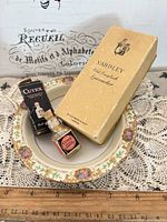 Overall lot showing Yardley box, Cutex bottle and box, floral porcelain saucer with ruler for scale