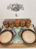 Overview of two shell dishes, four floral canisters on gold-tone rack