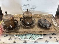 Full set on tray showing two lidded cup holders, sugar bowl, ornate tray