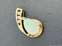 Front view of gold pendant showing opal and diamonds