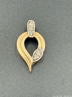 Front view showing teardrop shape, diamond-set bail and leaf accent