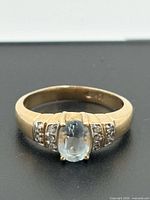 Front view of 10k yellow gold ring showing blue topaz and diamond accents