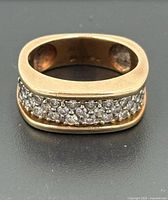 Front view of rectangular gold ring showing diamond pavé channel