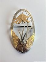 Front view showing full brooch design and mixed metals