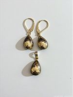 Front view of earrings and pendant showing overall design and matching teardrop shapes