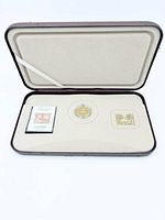 Open presentation case showing all components: coin, stamp replica, postage stamp