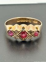 Front view of gold ring showing rubies and accent stones
