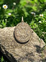 Front view of silver locket showing Hindu deity on Garuda