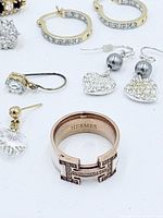 Close view of Hermes ring, gold-tone hoops, heart dangle earrings and assorted singles