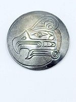 Front view of pendant showing engraved First Nations bird motif