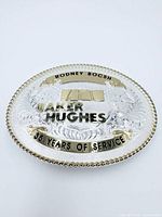 Front of Montana Silversmiths belt buckle showing inscription, gold rope edge and scrollwork