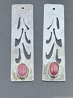 front view of both pendants showing cut-out design and star ruby cabochons