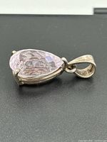 Side view of pendant showing pear-shaped rose quartz in silver setting