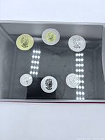 Open specimen set showing six coins in holder