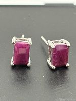 front view of both emerald-cut ruby stud earrings in sterling silver settings