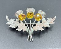 Front view of sterling silver thistle brooch with three citrine stones