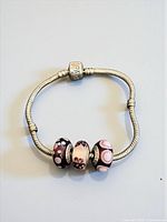 Full view of bracelet laid flat showing chain and three beads