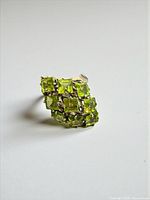 Angled front view of peridot cluster ring highlighting gemstone arrangement