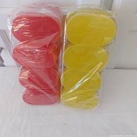 Front view of two sealed stacks, red and yellow glycerin soap bars